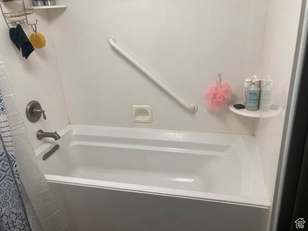 Full bathroom with a shower with shower curtain and a bathtub