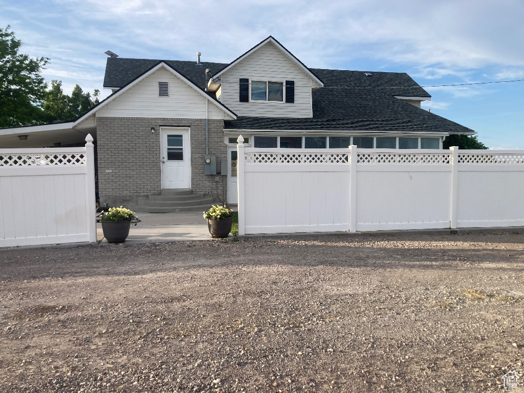 View of front of property with entry steps, brick siding, and a shingled roof