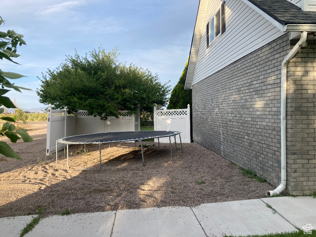 View of home's exterior with a trampoline and brick siding