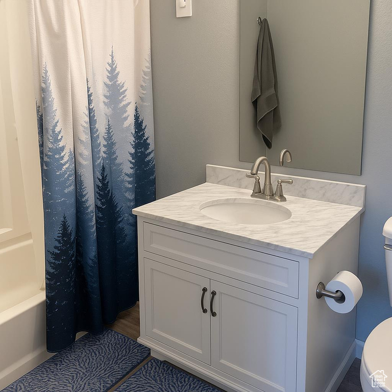 Full bath with toilet, vanity, and shower / bath combo