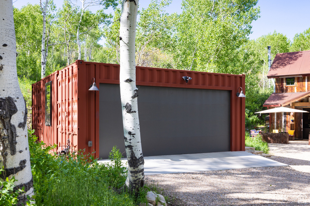View of front of property featuring a garage and gravel driveway