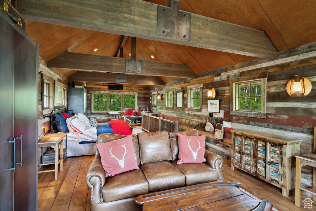 Living area featuring wood-type flooring, plenty of natural light, wood ceiling, and wooden walls
