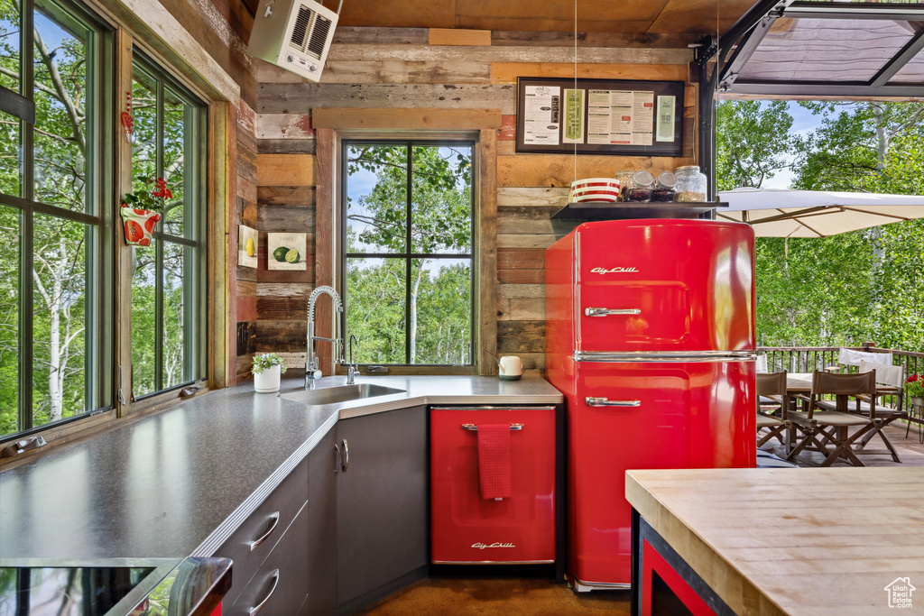Kitchen with a sink, wood walls, refrigerator, and range