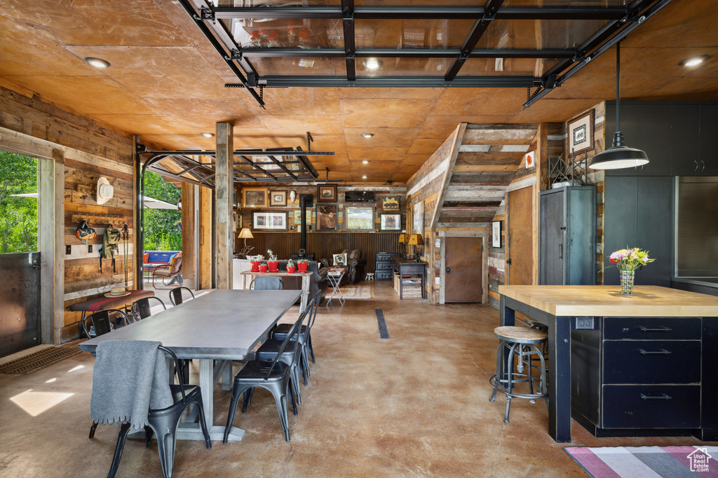 Dining area featuring concrete flooring and wooden walls