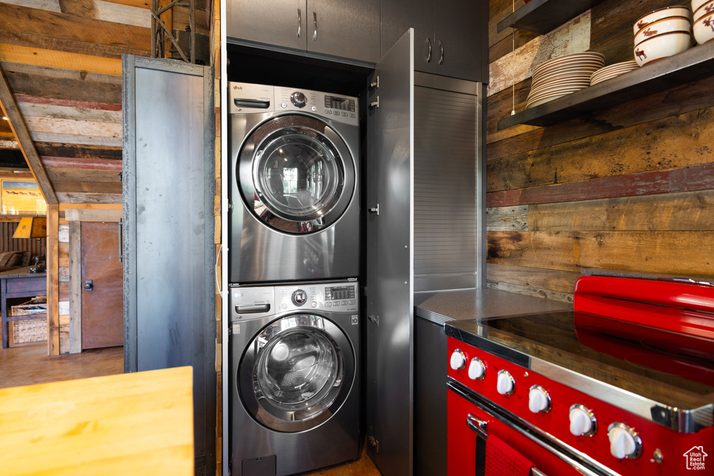 Washroom with estacked washer and dryer and wooden walls