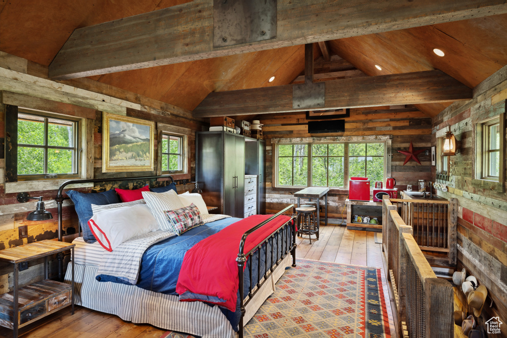 Bedroom with hardwood / wood-style floors, wooden walls, multiple windows, and recessed lighting