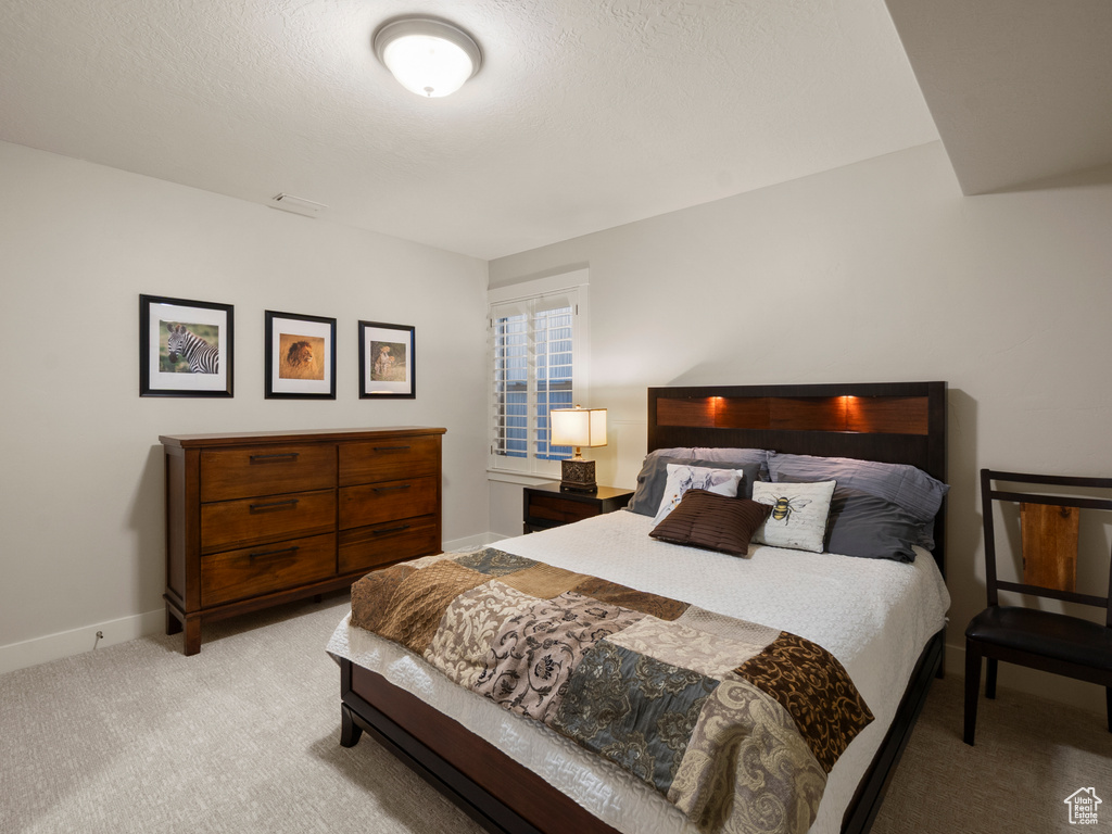 Bedroom with light carpet and baseboards