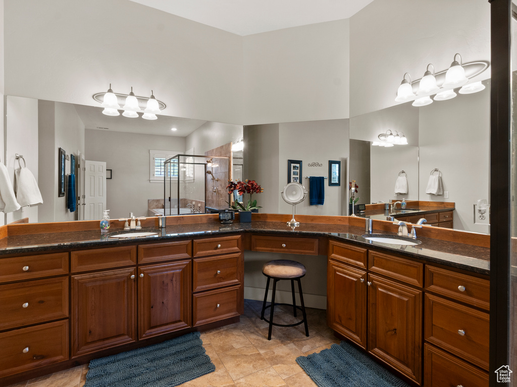 Full bath with a shower stall and vanity