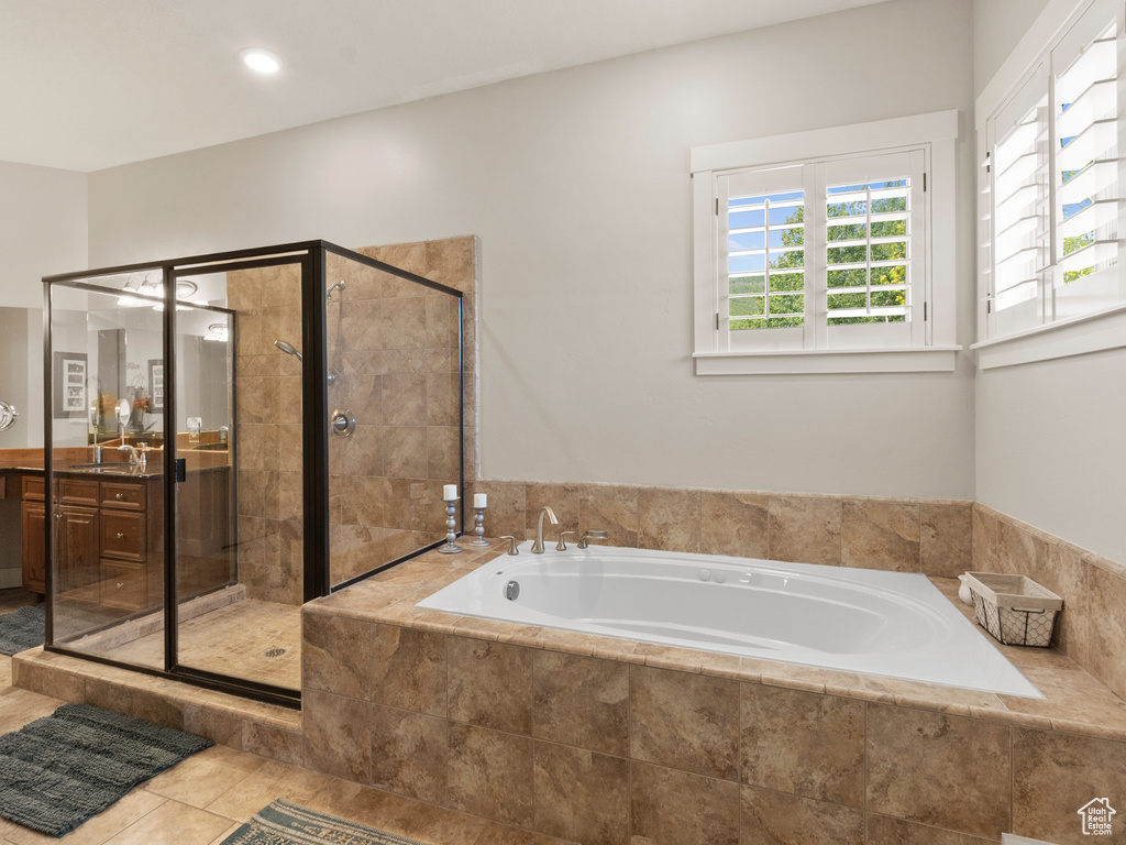 Full bath featuring a stall shower, a garden tub, vanity, and tile patterned flooring