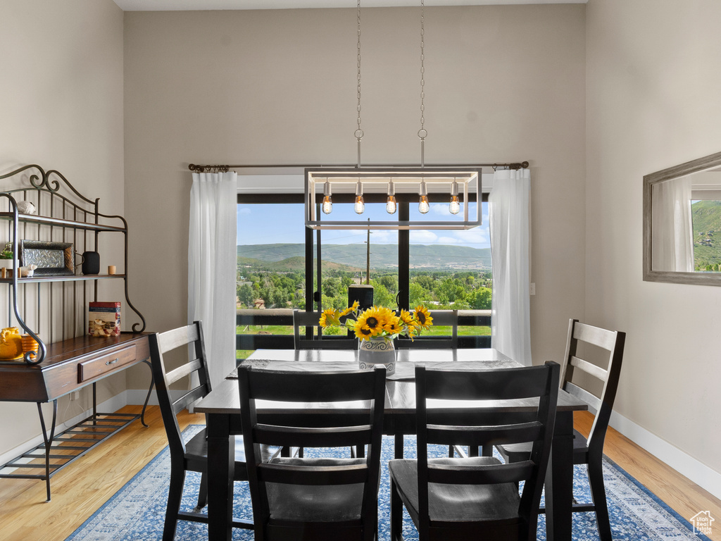 Dining space featuring a high ceiling, wood finished floors, and baseboards
