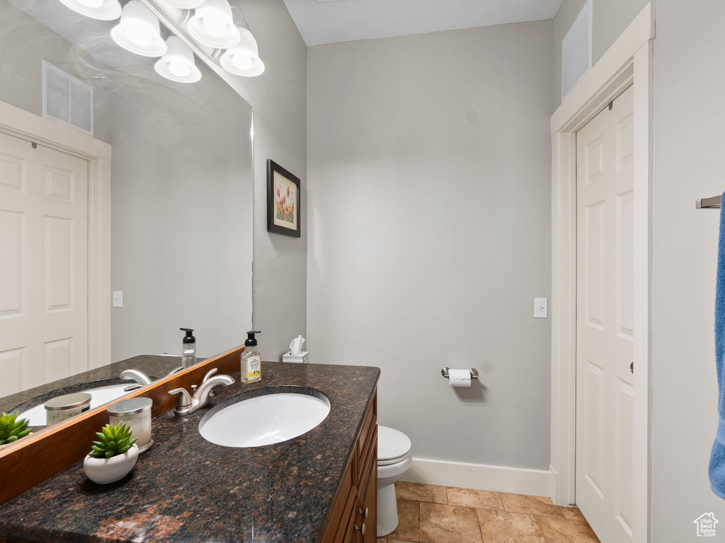 Bathroom with baseboards, vanity, and toilet