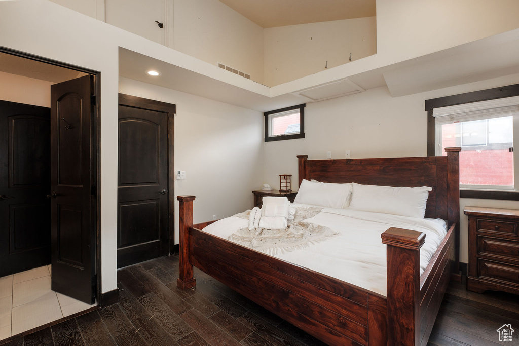 Bedroom featuring dark wood finished floors and a high ceiling