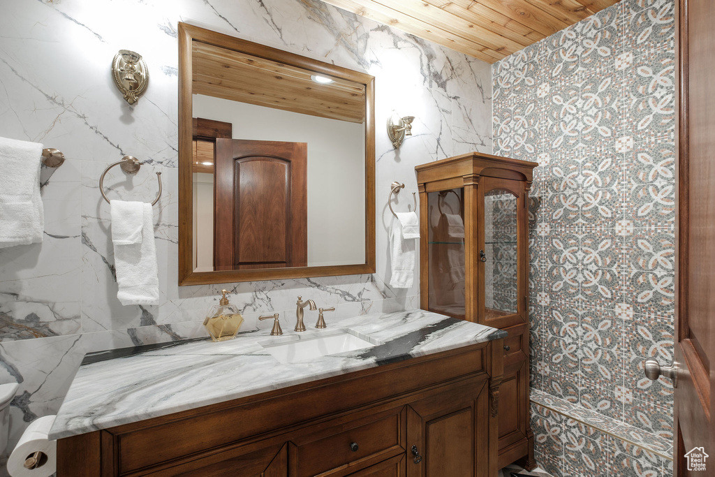 Bathroom featuring wooden ceiling, vanity, and toilet