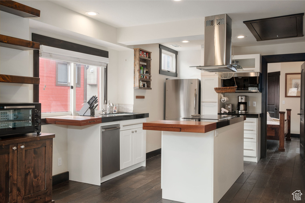 Kitchen featuring open shelves, island exhaust hood, appliances with stainless steel finishes, wood counters, and recessed lighting