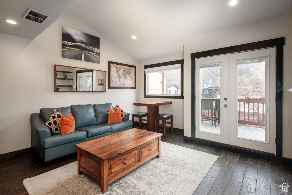 Living area with french doors, hardwood / wood-style floors, lofted ceiling, recessed lighting, and baseboards