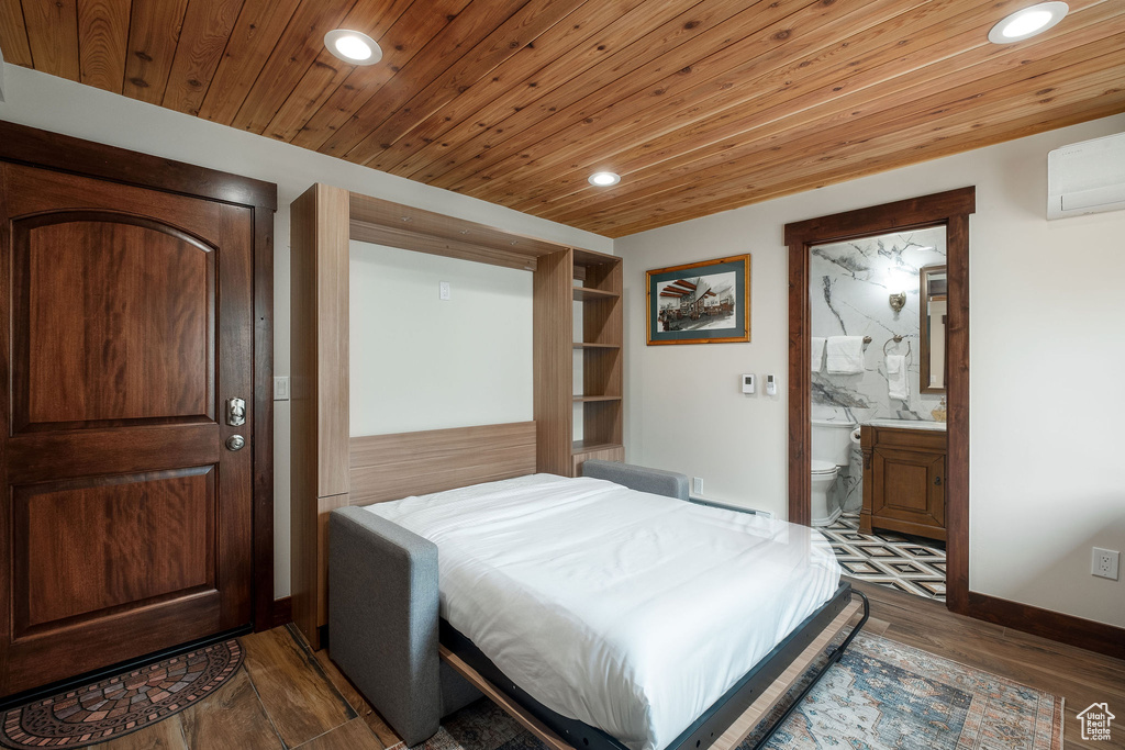 Bedroom with recessed lighting, a wall mounted AC, dark wood-type flooring, wooden ceiling, and ensuite bath