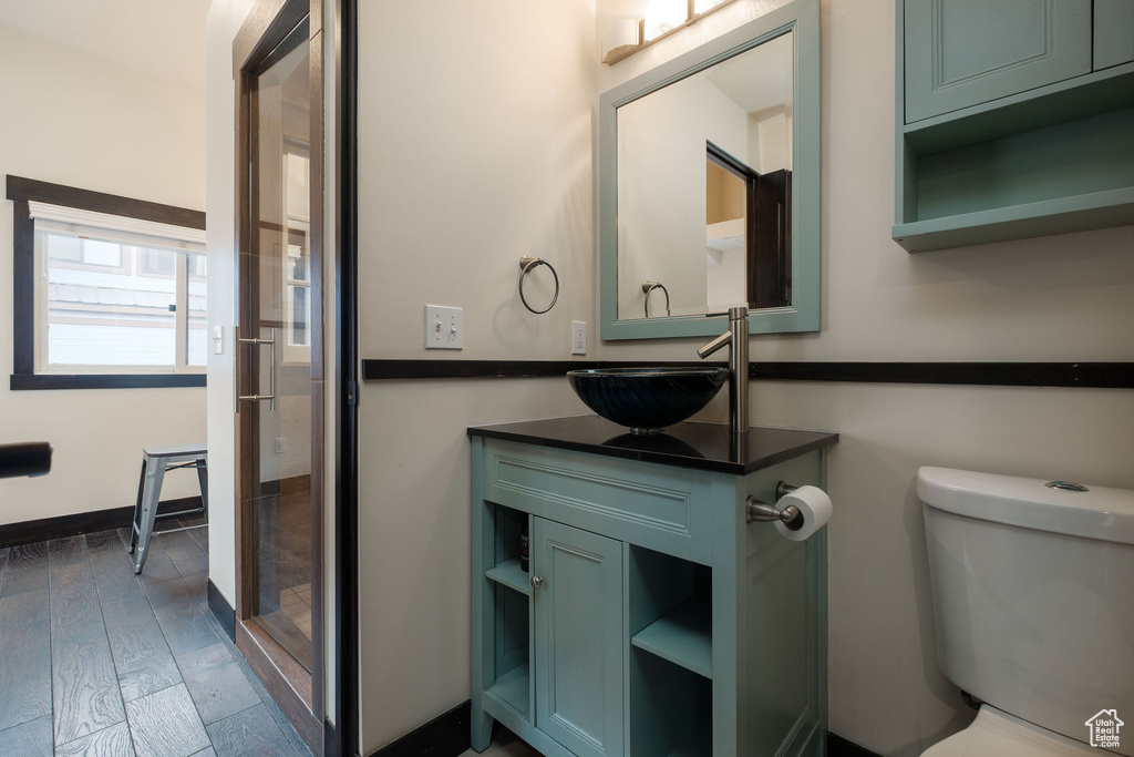 Bathroom with vanity, toilet, and wood finished floors