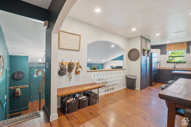 Dining area featuring light wood-type flooring, baseboards, arched walkways, and recessed lighting