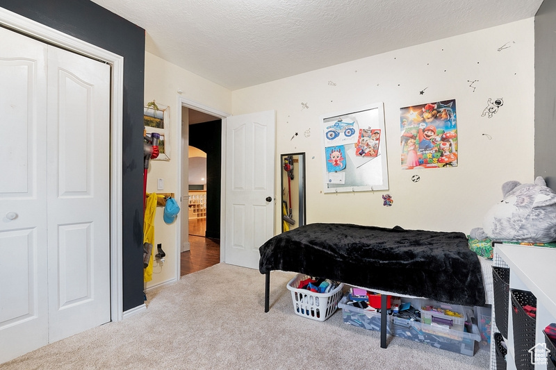 Carpeted bedroom with arched walkways and a closet
