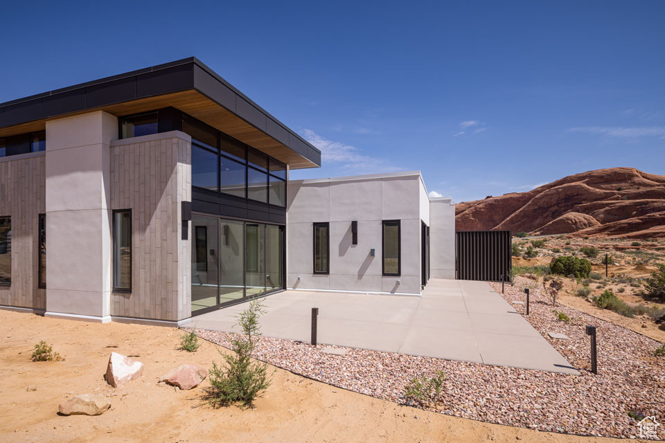 Rear view of property featuring a mountain view and a patio
