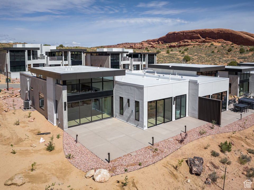 Back of house featuring a mountain view, a patio, and stucco siding
