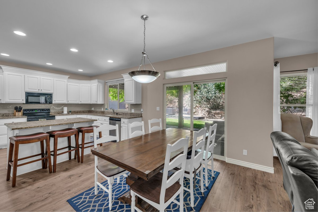 Dining room with light wood-style floors and recessed lighting