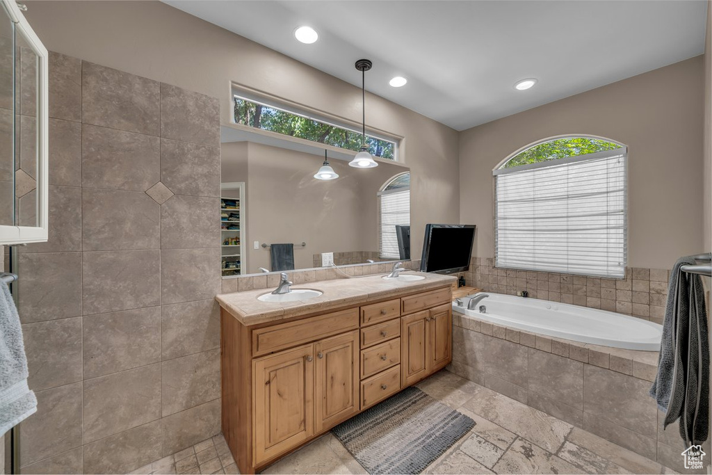 Bathroom with a bath, double vanity, and recessed lighting