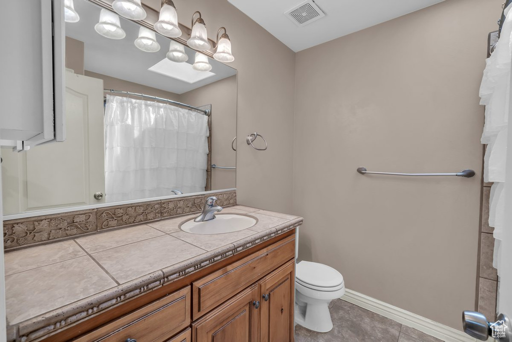 Bathroom with vanity, tile patterned floors, and curtained shower