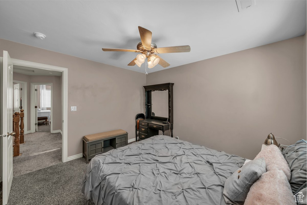 Carpeted bedroom with ceiling fan and baseboards