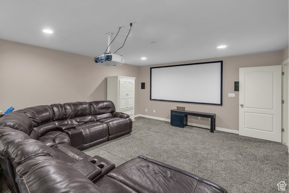 Carpeted cinema room with recessed lighting and baseboards