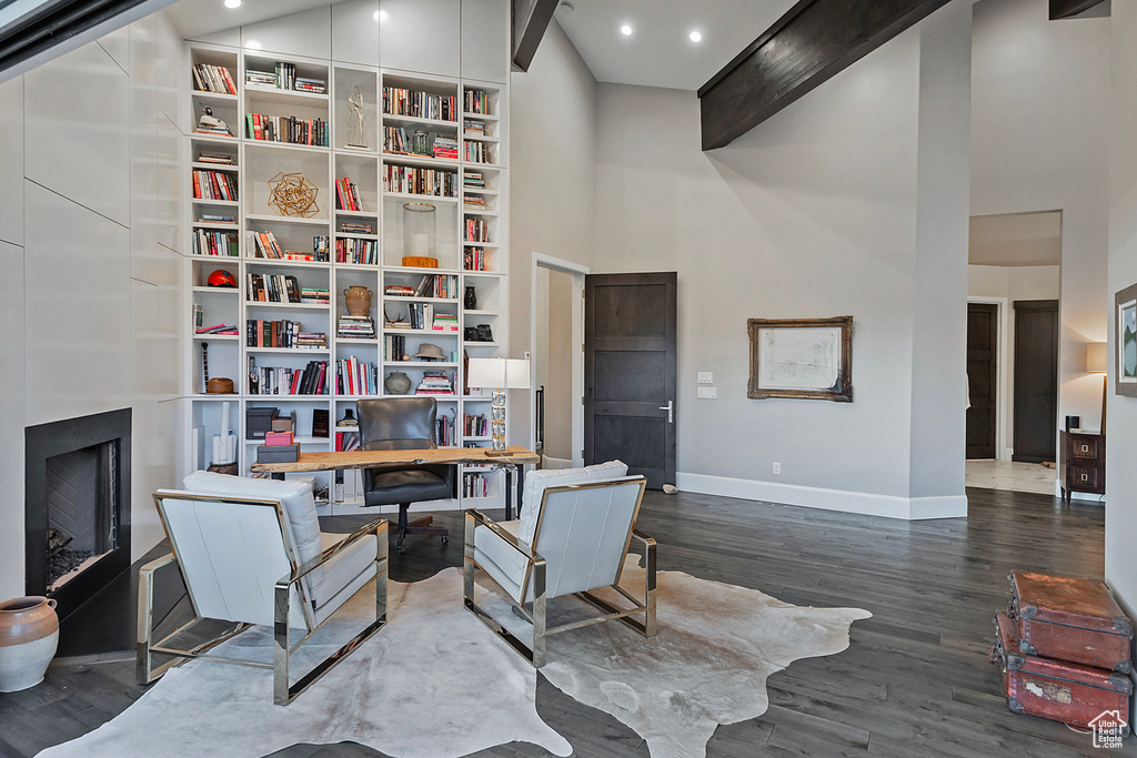 Home office with baseboards, a high ceiling, dark wood-style flooring, recessed lighting, and a fireplace