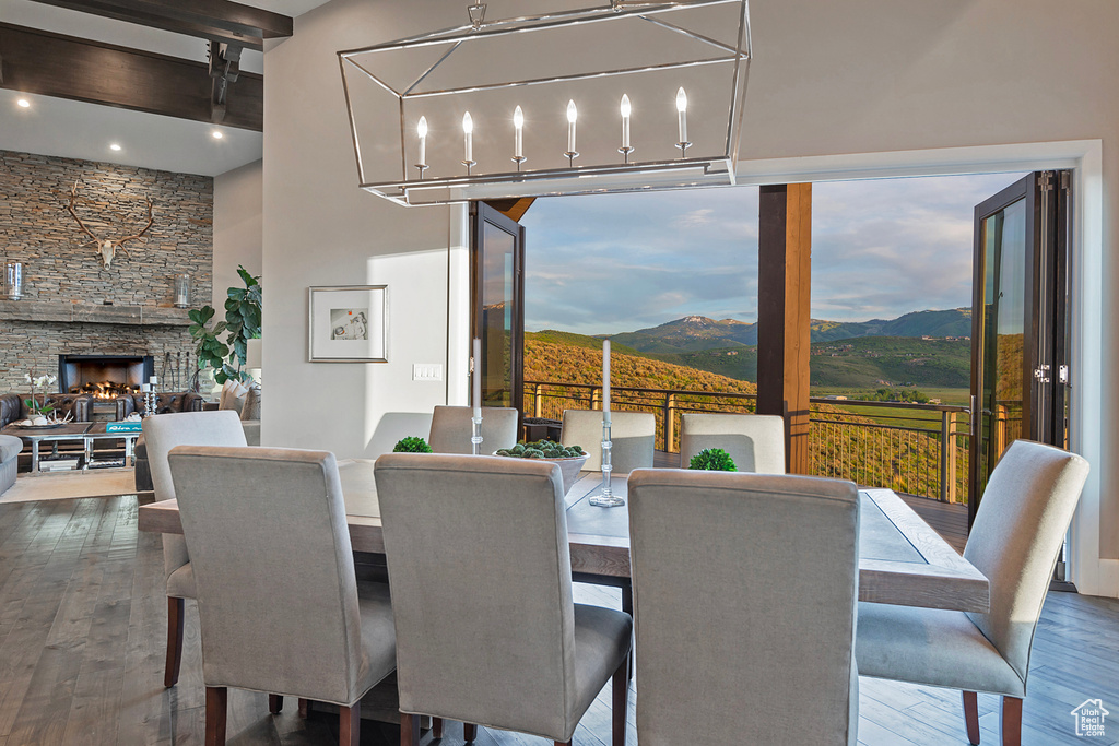 Dining space featuring wood finished floors, a mountain view, a stone fireplace, and recessed lighting