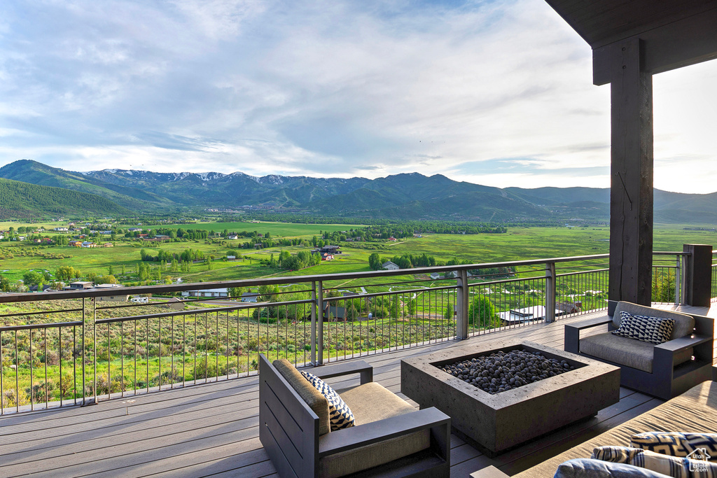 Wooden terrace with a view of rural / pastoral area, a mountain view, and an outdoor living space with a fire pit