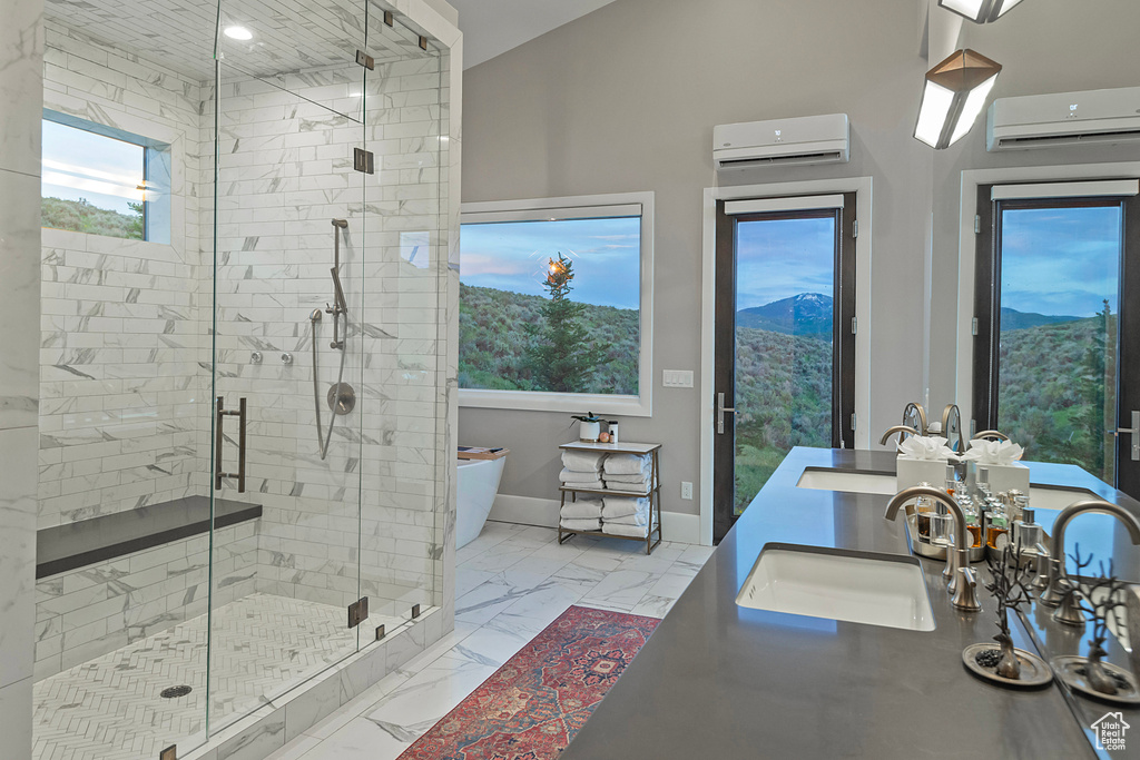 Full bathroom with a wall unit AC, a soaking tub, marble finish flooring, a stall shower, and double vanity