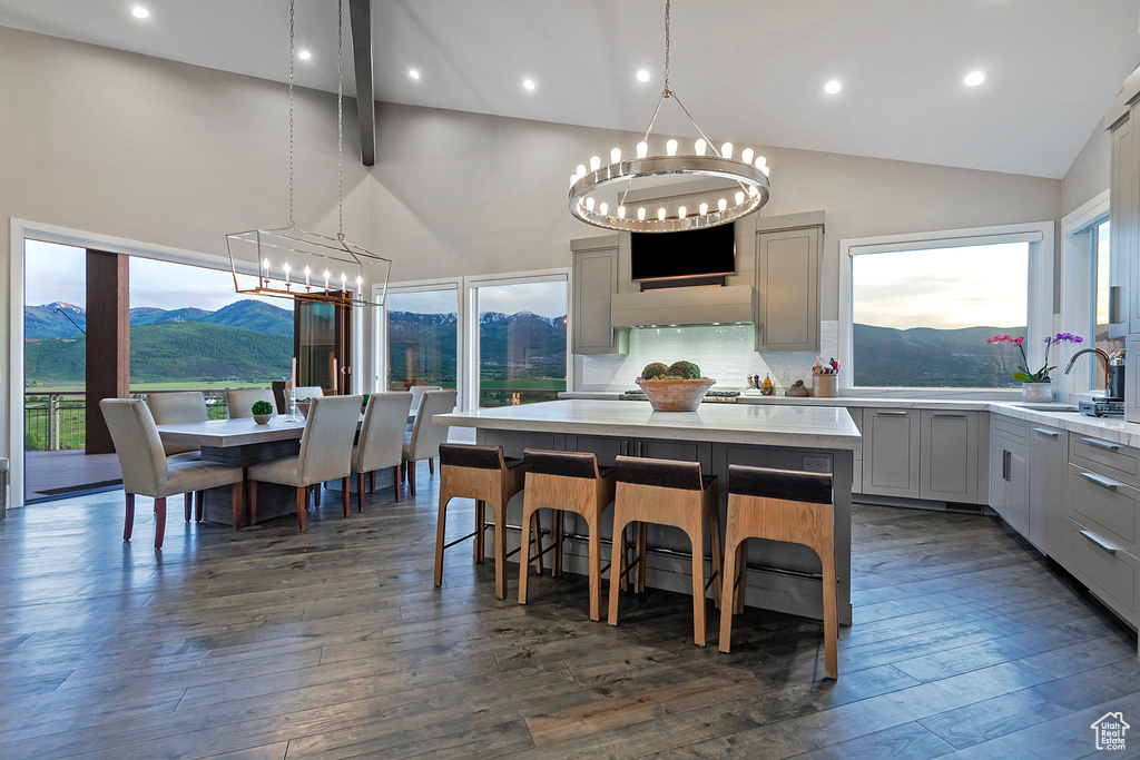 Kitchen featuring a chandelier, a sink, light countertops, gray cabinetry, and a center island