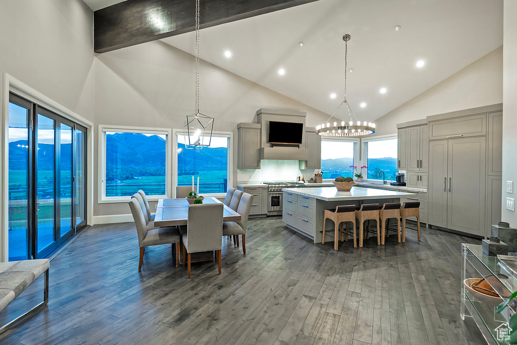 Dining space with high vaulted ceiling, a chandelier, dark wood finished floors, and recessed lighting