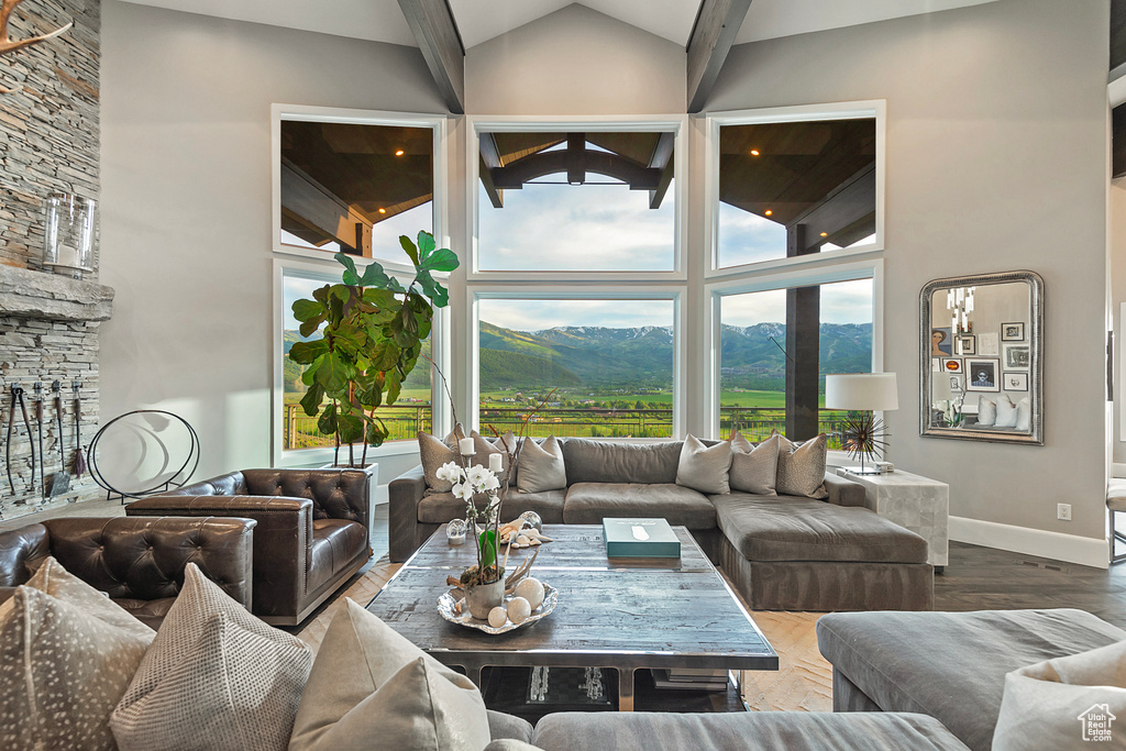 Living area featuring high vaulted ceiling, a mountain view, and baseboards
