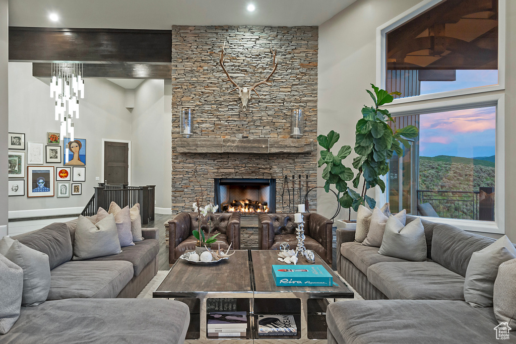Living room with a high ceiling, a fireplace, baseboards, and a mountain view