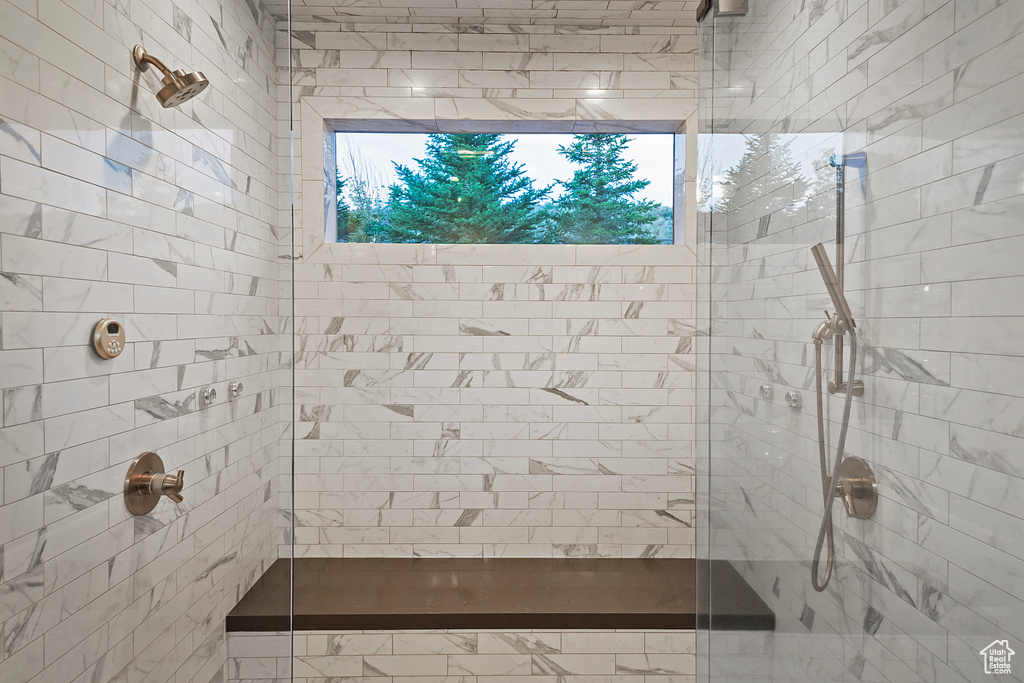 Bathroom with a tile shower and plenty of natural light