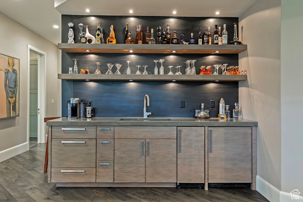 Indoor wet bar featuring dark wood-style floors, baseboards, and recessed lighting