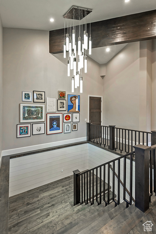 Stairway with wood finished floors, recessed lighting, a towering ceiling, and baseboards