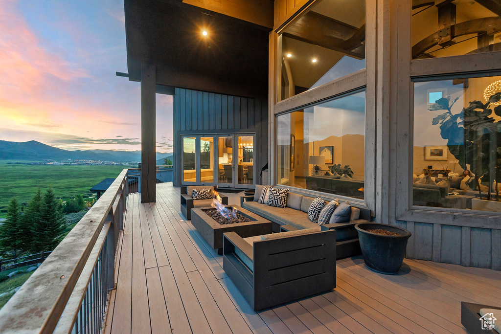 Wooden deck featuring an outdoor living space with a fire pit and a mountain view