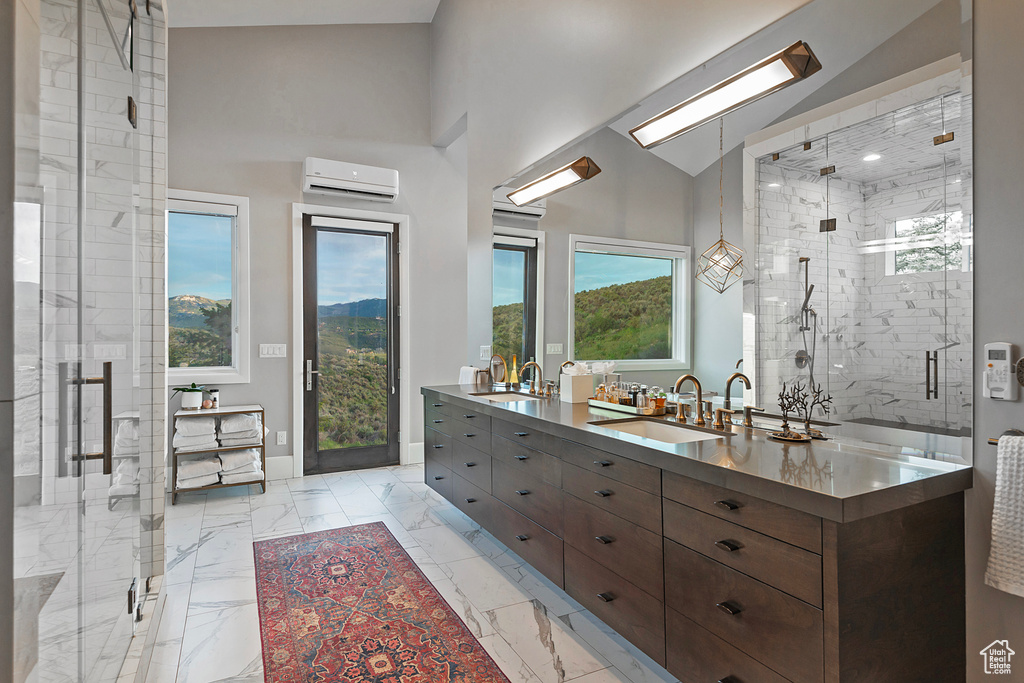 Bathroom featuring double vanity, plenty of natural light, a marble finish shower, marble finish flooring, and a high ceiling