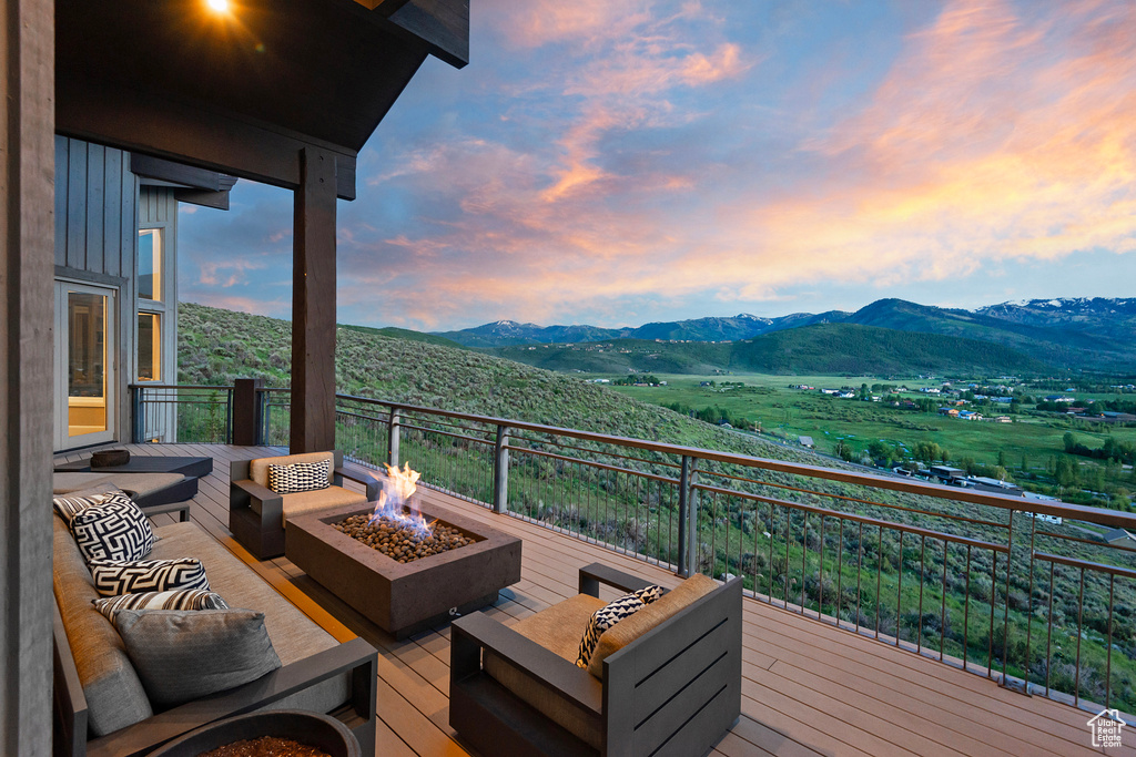 Wooden deck with an outdoor living space with a fire pit and a mountain view