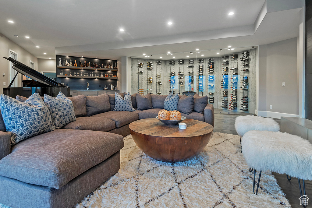 Living room with bar, recessed lighting, and baseboards