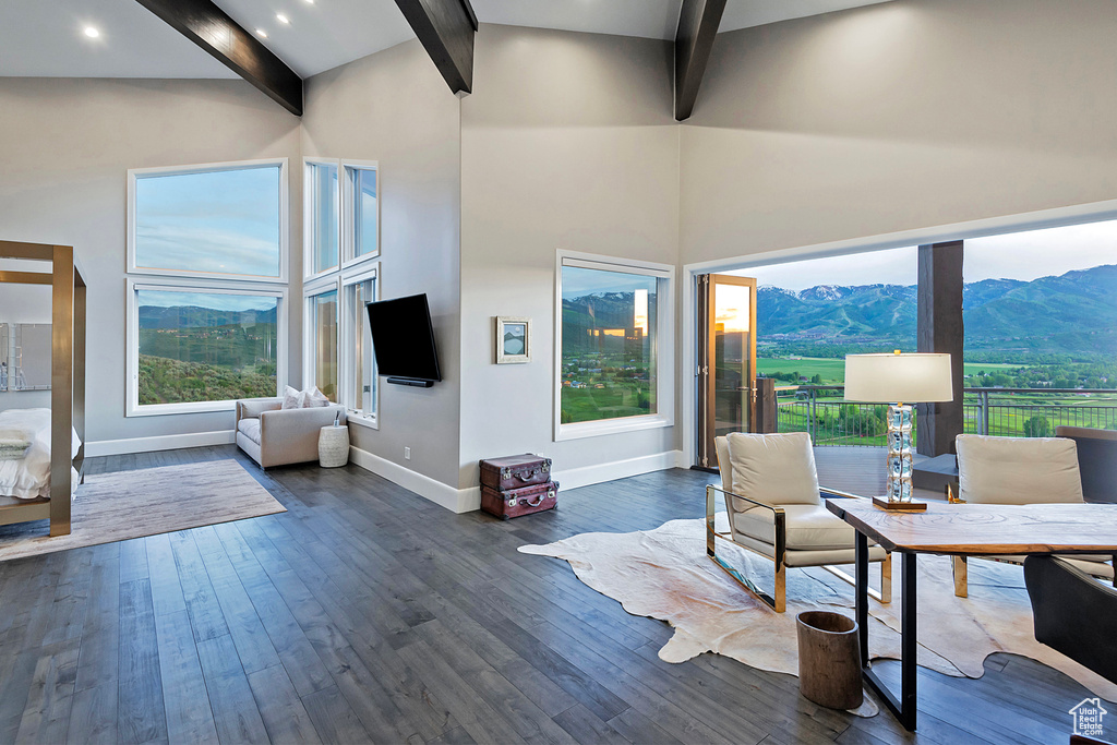 Living area with beam ceiling, dark wood-type flooring, plenty of natural light, and high vaulted ceiling