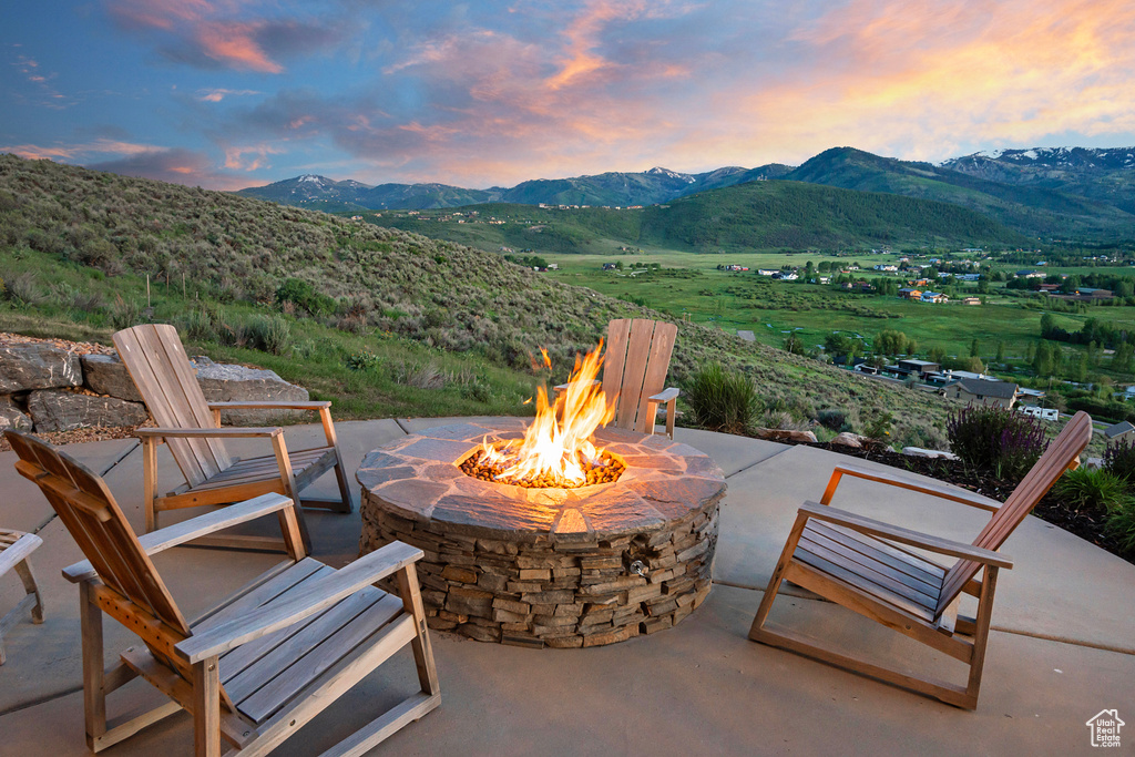 Patio terrace at dusk with an outdoor fire pit, a patio area, and a mountain view