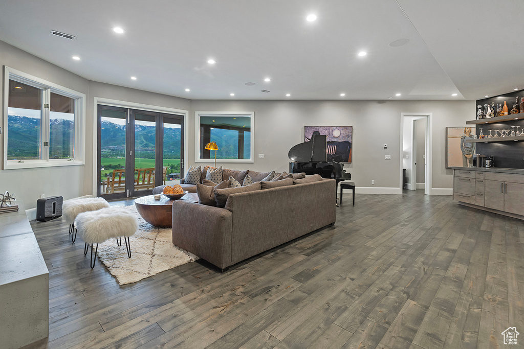 Living area featuring wood finished floors, recessed lighting, a dry bar, and baseboards