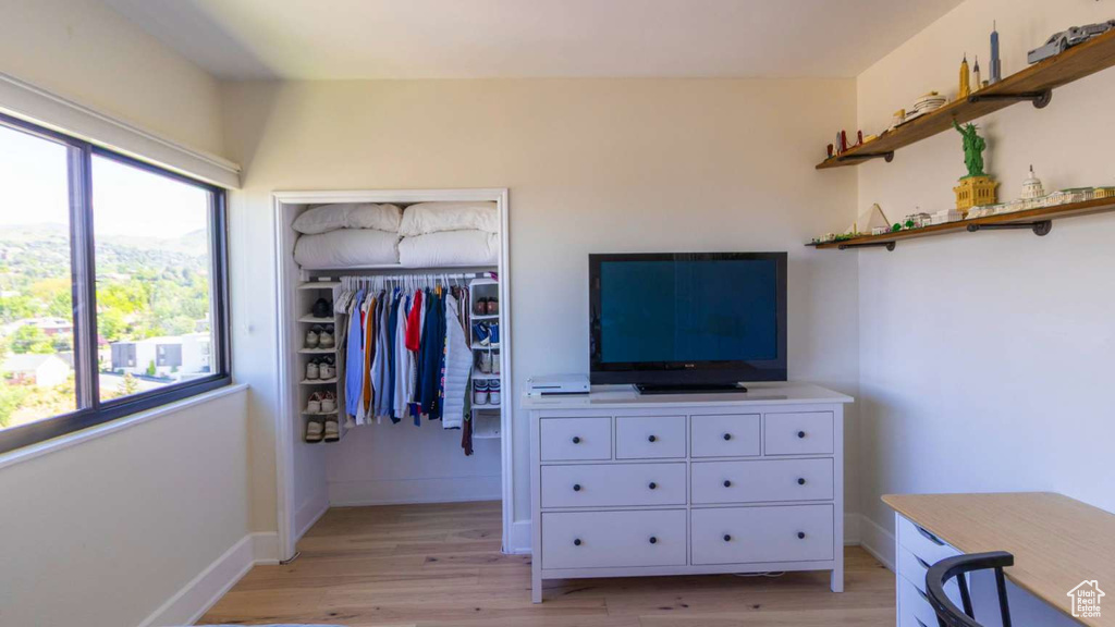 Bedroom with light wood-style floors, a closet, and baseboards
