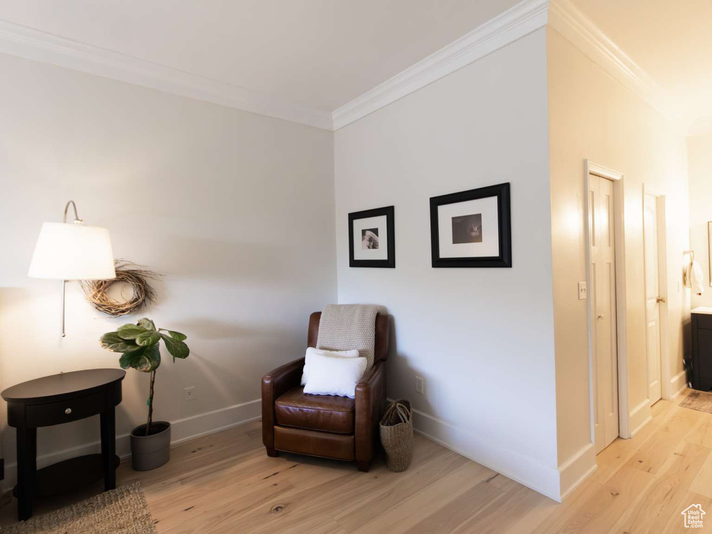 Sitting room with ornamental molding, wood finished floors, and baseboards